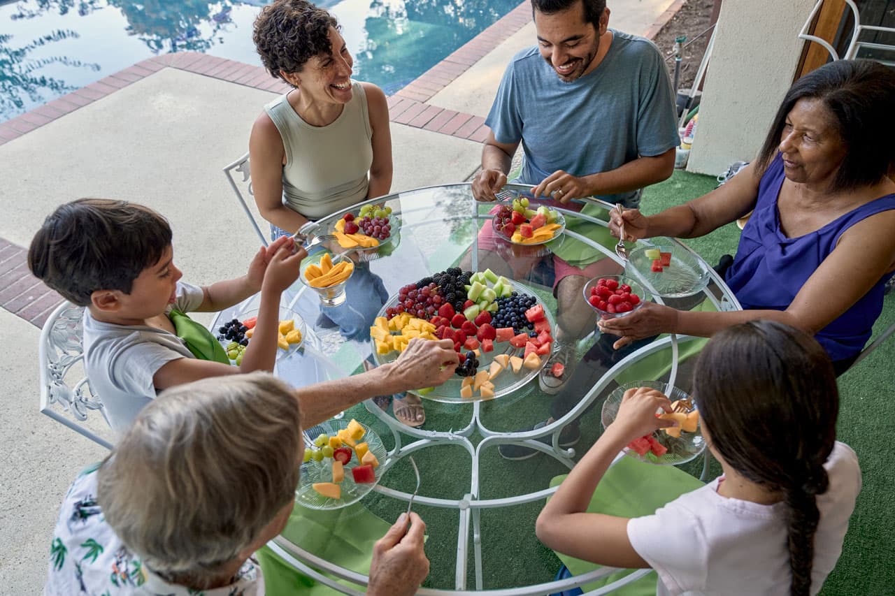 People laughing eating fruit